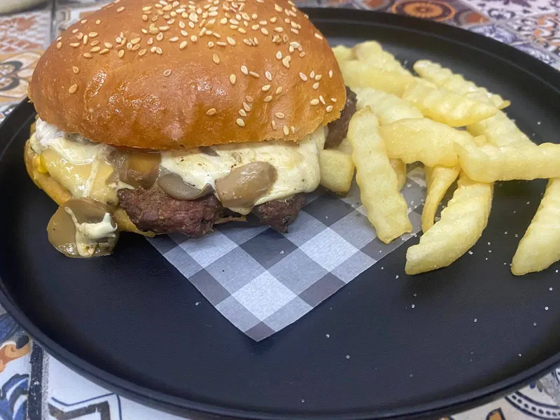 Hamburguesa con queso y champiñones, acompañada de papas